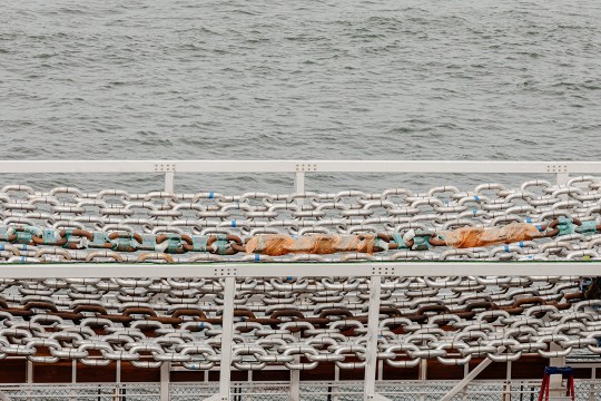 nine strands of large, linked chain in an art installment.