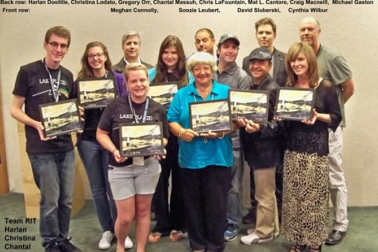 A group of 12 students stand for a group picture holding all of their awards, with the 4 RIT winners among them