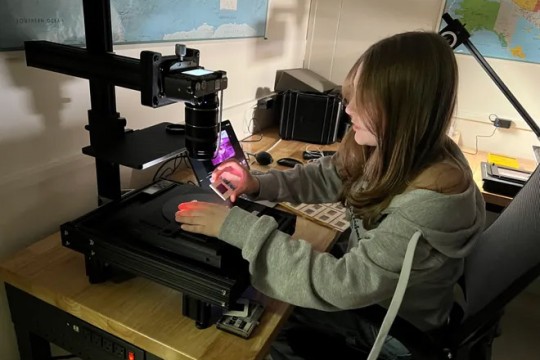 RIT student Lauren Anderson prepares to photograph a slide from the Beaversprite archive of conservationist Dorothy Richards.