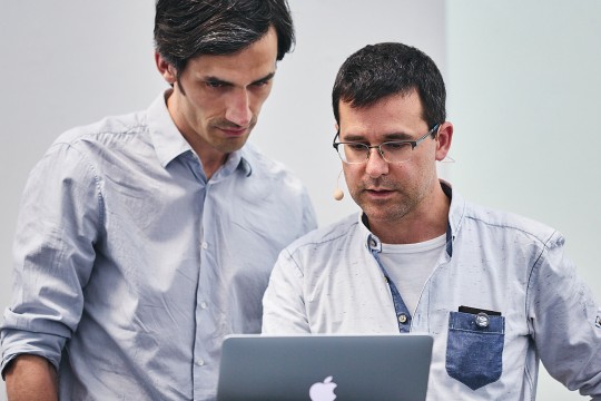 Georg Seifert and Rainer Schiechelbauer both look at a computer as they present.