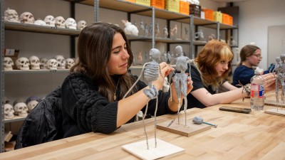 a student works on her clay sculpture of the human form.