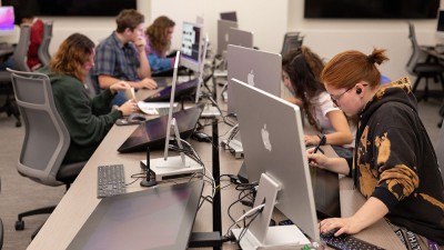 Students work at computer stations.