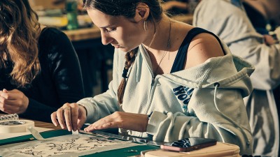 An RIT student puts a design together on paper.