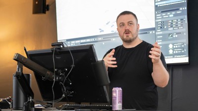 Faculty Aaron Powell at a computer station teaching.