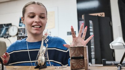 A student shows their metal creations. 