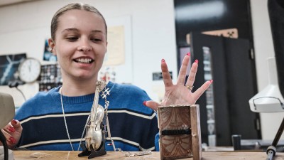 student with a small metal cello statue.