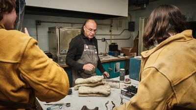 artist leads a demo at a workstation with protective leather gloves.