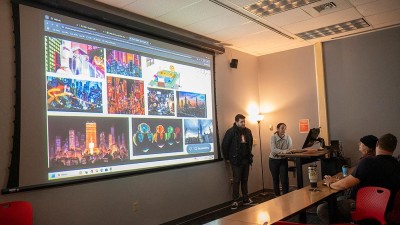 students show a collage of colorful city images on a screen.