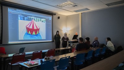 Students project work onto a screen for a critique.