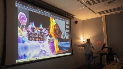 Students project work onto a screen for a critique.