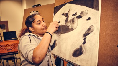 A student creates a still-life drawing.