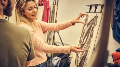 a faculty member gives feedback on a student's drawing.