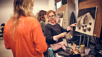 a faculty member gives feedback on a still life.