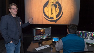 a professor gestures toward a projection of an overhead view of a bowl of bananas.