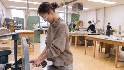 student uses a sander on a project.
