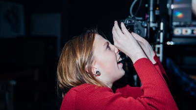 a student looks up through small binoculars.