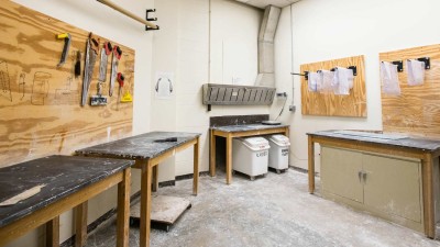 Workroom with workbenches with hand saws hanging from the wall