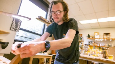 An R I T student works with hand tools in the furniture design studio.