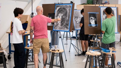 Faculty Denton Crawford gives feedback on a student's portrait.