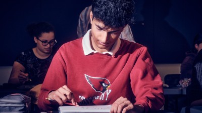 head-on view of a student shading in his drawing.