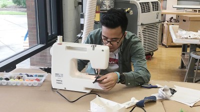 student uses a sewing machine in a studio.
