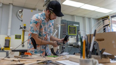 student snips wires in a maker space.