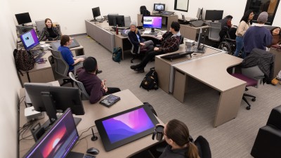 students sitting at several workstations with computers and drawing pads called Cintiqs.