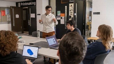 Students and faculty interact in a studio setting.