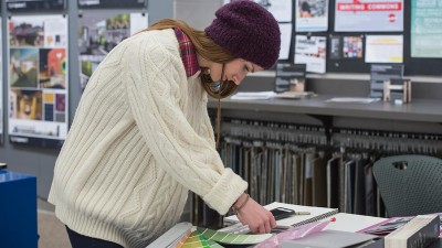 A student looks at material and color options for a project from the RIT interior design program's Material Resource Center.