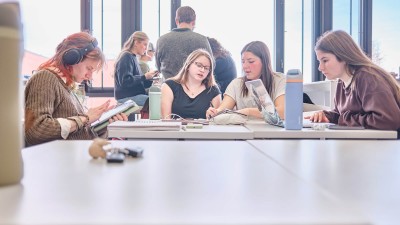 four students work together at a table.