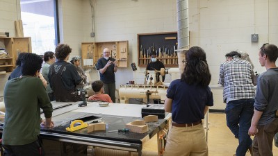 Visiting artist Daniel Michalik addresses students in the machine room.