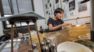a student works on a small box at a workspace.