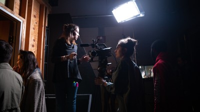 student film crew working with a camera with a bright light.