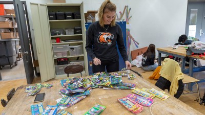 A student spreads dozens of lottery tickets across a table.
