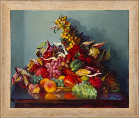 Bright and colorful still life display of fruits and vegetables on an overflowing platter, on top of a wooden table.