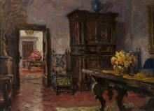 A view into a room with dark brown wood fixtures with a matching armoire, chair, and table.  On top of the table there is a vase of bright yellow and orange flowers. On the left side in the background there is a doorway to the next room where another bouquet of bright red flowers can be seen.