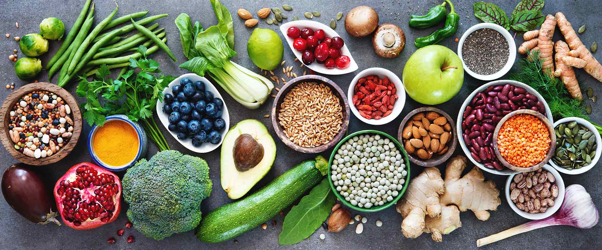 A colorful assortment of fresh fruits, vegetables, grains, and nuts displayed on a table.