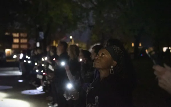 Big Shot volunteers shine their flashlights on the Susan B. Anthony Museum and House.