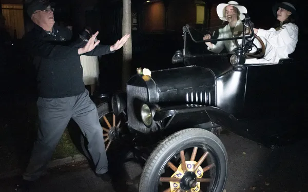 RIT President David Munson pretends to nearly be struck by an old-time car, placed as a prop for the Big Shot.