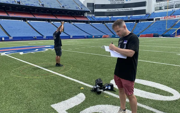 Dan Hughes and Eric Kunsman on the field at Highmark Stadium documenting tests for the Big Shot.