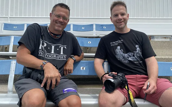 Dan Hughes and Eric Kunsman sit next to each other in Highmark Stadium seats.