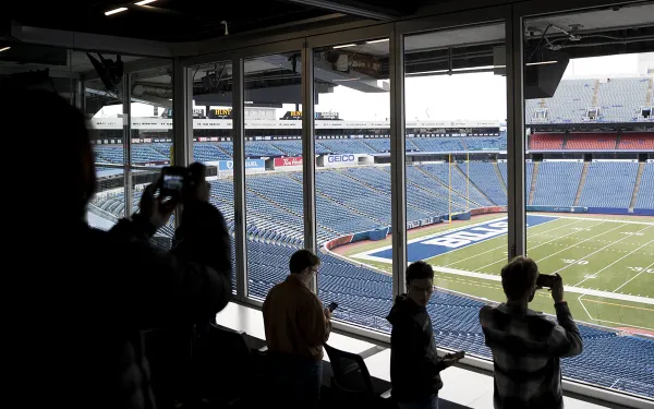 Students take photos of the Highmark Stadium field from the press box.