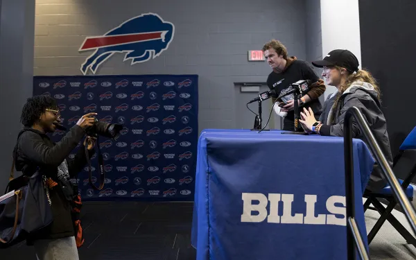 Students sit at a press conference table.