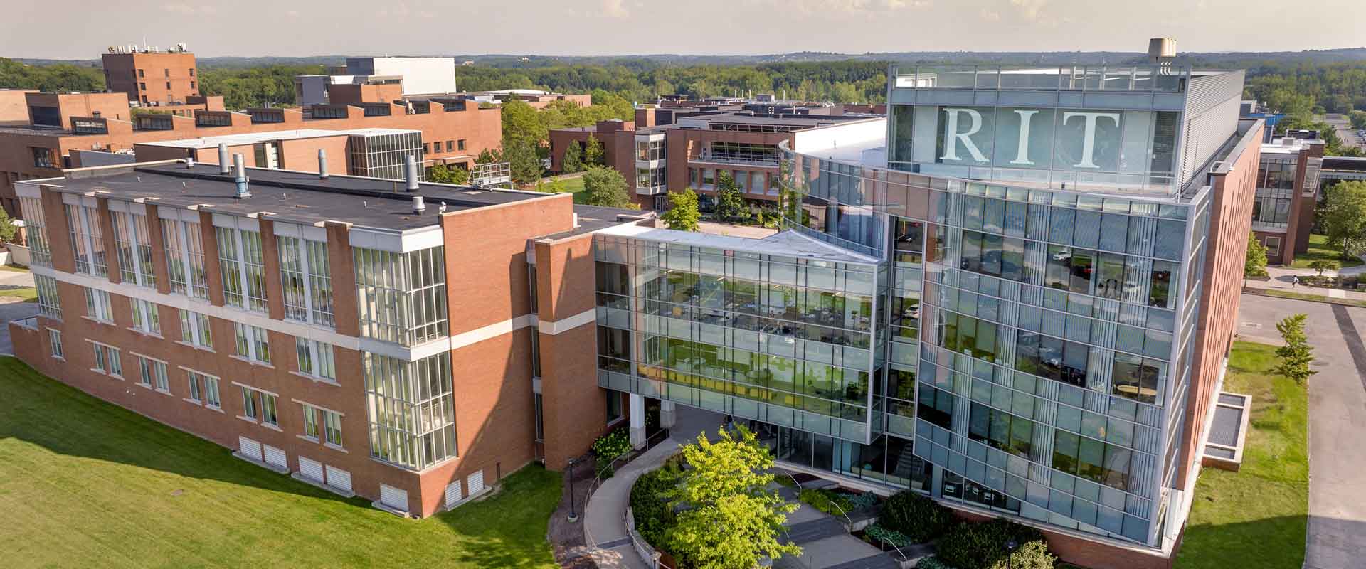 aerial view of a brick and glass building on the R I T campus.