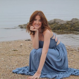 Student in a blue dress on a beach