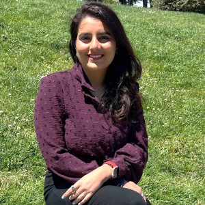 Female student smiling sitting in a grass field