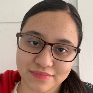 Student with glasses smiling at camera