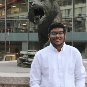 Image of Ishan standing in front of the tiger statue