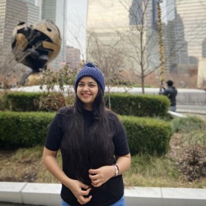 Shreeya standing outside in a city park.