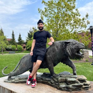 Study in a black beanie by the RIT tiger statue.
